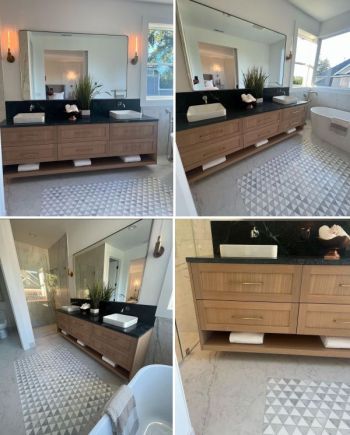 Modern bathroom with double wood vanity, black countertops, and large mirror in a bright home interior